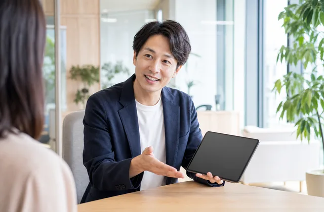 明るいオフィスで通信サービスについて説明するスタッフ
